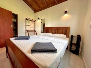 a bedroom with a large bed with towels on it at Body,Mind & Soul in Bentota