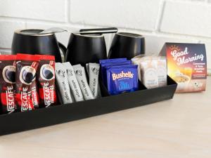 a shelf with a bunch of drinks and other snacks at Centrepoint Motor Inn in Rockhampton +39 photos