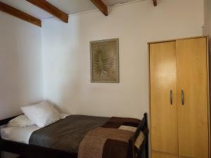 a bedroom with a bed and a wooden cabinet at Tambo Norte in San Pedro de Atacama