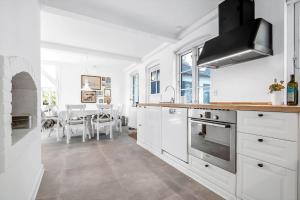 a kitchen with white cabinets and a dining room at 3331-Stege-Raby-Sovej-1 in Stege