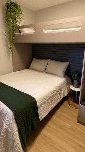 a bedroom with a white bed with a black headboard at Luxury flat in Monte Castelo in Sairé