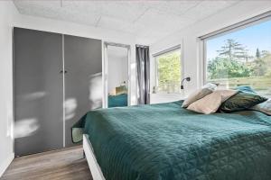 a bedroom with a green bed and a window at S742-Stroby-Garderhojen-32 in Strøby