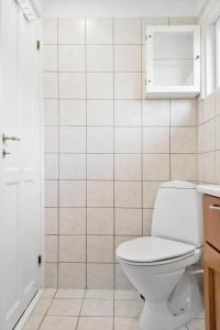 a white bathroom with a toilet and a shower at S742-Stroby-Garderhojen-32 in Strøby +14 photos