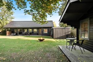 a backyard with a table and chairs on a deck at S742-Stroby-Garderhojen-32 in Strøby
