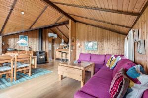 a living room with a purple couch and a table at R971-Rodvig-Stuven-65 in Rødvig