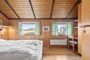 a bedroom with a bed and two windows at R971-Rodvig-Stuven-65 in Rødvig