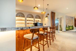 a kitchen with a bar with stools at Villa Karilla in Toyapakeh
