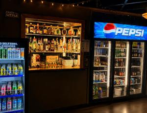 a bar with a lot of bottles of soda at Ste Anne Hotel in Sainte Anne-des-Chênes