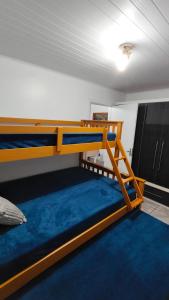 a bedroom with two bunk beds and a blue carpet at Propriedade Mendes&Souza - Pinhais in Pinhais