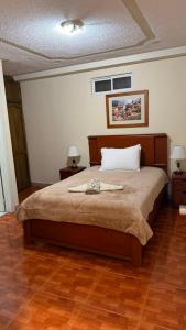 a bedroom with a large bed with two tables and two lamps at Hostal kimbala in Cotacachi