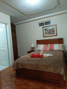 a bedroom with a bed with a red robe on it at Hostal kimbala in Cotacachi