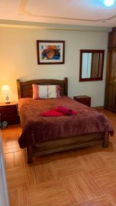 a bedroom with a bed with a red robe on it at Hostal kimbala in Cotacachi