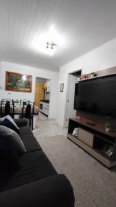 a living room with a couch and a flat screen tv at Propriedade Mendes&Souza - Pinhais in Pinhais