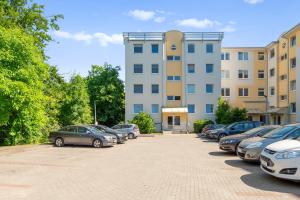a parking lot with cars parked in front of a building at Słoneczny Widok in Gdynia