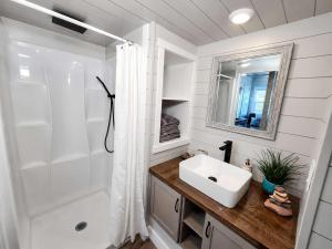 a white bathroom with a sink and a shower at Tiny Home with Private Hot Tub, Zion Adventure Base in Apple Valley