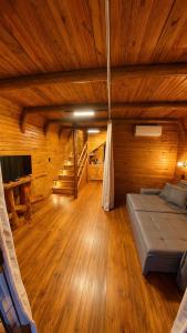 a room with a bed in a wooden room at Chalé Suíco Vale do Capão in Palmeiras