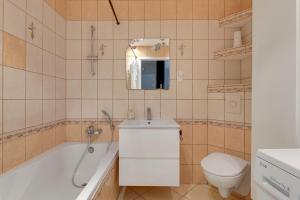 a bathroom with a tub and a toilet and a sink at Słoneczny Widok in Gdynia +18 photos