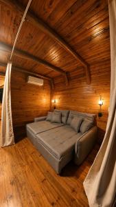 a bedroom with a bed in a wooden room at Chalé Suíco Vale do Capão in Palmeiras