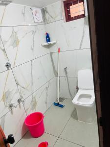 a bathroom with a toilet and a red bucket at CHRIS COZY FARM cottage in Wayanad +15 photos