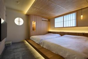 a bedroom with two beds and a window at Hotel Matoma 別館 in Tokyo