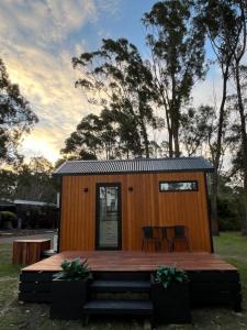a tiny house with a deck and two chairs at BIG4 Sale Caravan Park in Sale
