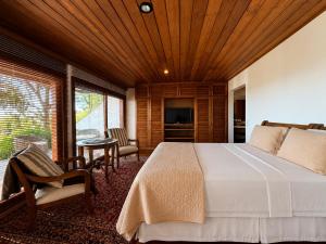 a bedroom with a large bed with a wooden ceiling at Hortênsia Boutique - Chalés de Luxo & Suítes Privativas in Campos do Jordão
