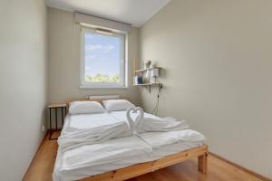 a bed in a room with a window at Słoneczny Widok in Gdynia