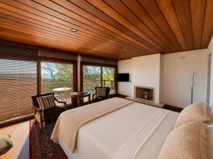 a bedroom with a large bed and a fireplace at Hortênsia Boutique - Chalés de Luxo & Suítes Privativas in Campos do Jordão +71 photos