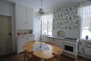 a kitchen with a wooden table and a table and chairs at Ljungås Gamla Skola in Askersund