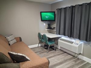 a living room with a couch and a table and a tv at Hinton Highway Inn in Hinton
