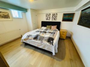 a bedroom with a bed and a wooden floor at Langafit Guest house in Garðabær