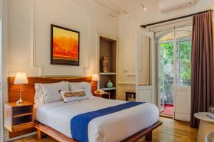 a bedroom with a large bed and a window at Hotel Villa Condesa in Mexico City +52 photos