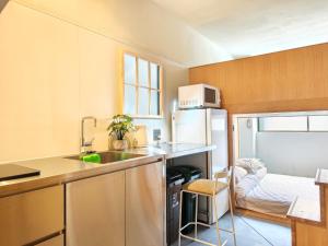 a small kitchen with a sink and a bed at Hotel Matoma 別館 in Tokyo +16 photos