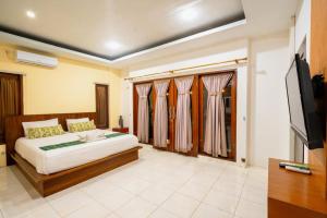 a bedroom with a bed and a flat screen tv at Melati Kuta Lombok in Kuta Lombok