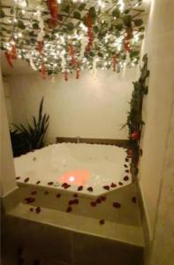a room with a bath tub with christmas lights at Hotel Jade Imbanaco in Cali