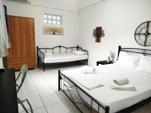 a bedroom with two beds and a table and chairs at Sarantakis Apartments in Agios Andreas