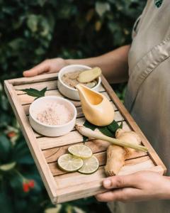 a person holding a wooden tray with food on it at My Eliana Luxury Hotel Saigon Saigon & Spa in Ho Chi Minh City