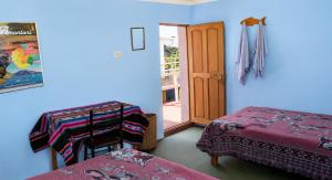 a room with blue walls and two beds and a door at Dawn House - Lago Titicaca in Ocosuyo