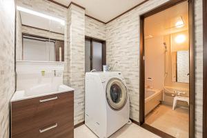 a bathroom with a washing machine and a sink at 富士飛鳥 in Fujiyoshida