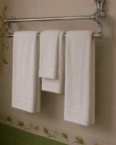 three towels are hanging on a towel rack in a bathroom at Green City Hotel ШАХРИСАБЗ in Khujand +26 photos