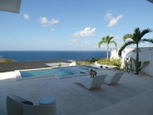 a swimming pool with a view of the ocean at The Siren Resort Nusa Penida - Ocean View Villas in Nusa Penida