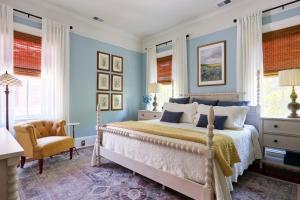 a bedroom with a bed with blue walls and a chair at Downtown Savannah Oasis in Savannah