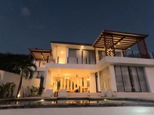 a villa with a swimming pool at night at The Siren Resort Nusa Penida - Ocean View Villas in Nusa Penida