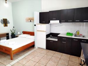 a small room with a bed and a kitchen at Sarantakis Apartments in Agios Andreas