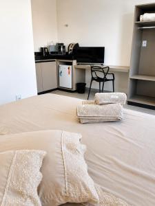 a large bed with two pillows on top of it at Alphaville Studios in Pirapora