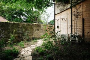 a brick wall next to a building with a door at 眠ル庭ーnemuruniwa in Tochigi