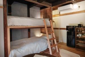 a bedroom with two bunk beds in a room at 眠ル庭ーnemuruniwa in Tochigi