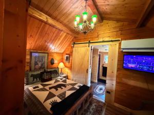 a bedroom in a log cabin with a bed and a tv at The Raven in Cosby