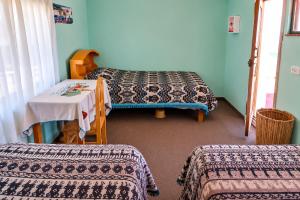 a room with two beds and a table with a table at Dawn House - Lago Titicaca in Ocosuyo +20 photos
