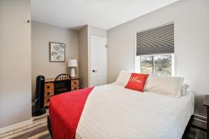 a bedroom with a bed with a red pillow on it at Spacious Colonial Large Groups Fire Pit in Brewer